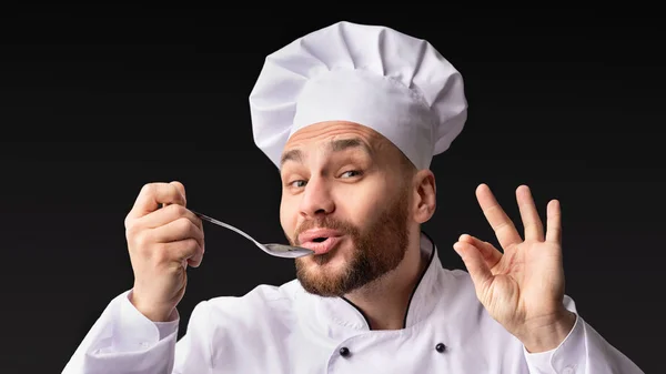 Chef ochutnávka a schvalování potravin držení lžička pózu ve studiu — Stock fotografie