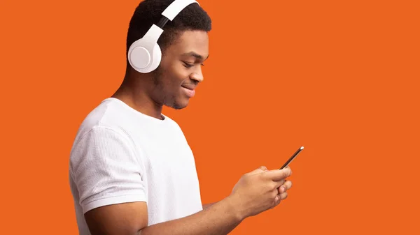 Widok z boku czarny człowiek w słuchawkach bezprzewodowych — Zdjęcie stockowe