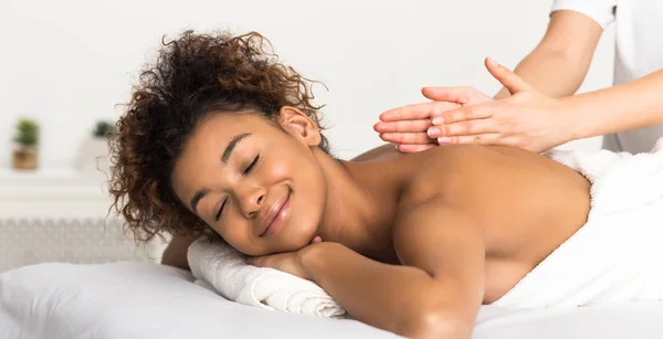 Klassisk ryggmassage. Afroamerikansk kvinna njuter av spabehandling — Stockfoto