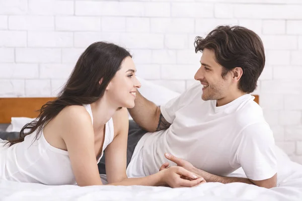 Happy spouses talking in bedroom, spending weekend together — 스톡 사진
