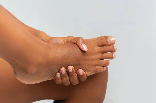 Cropped of black girl rubbing her foot — Stock Photo, Image