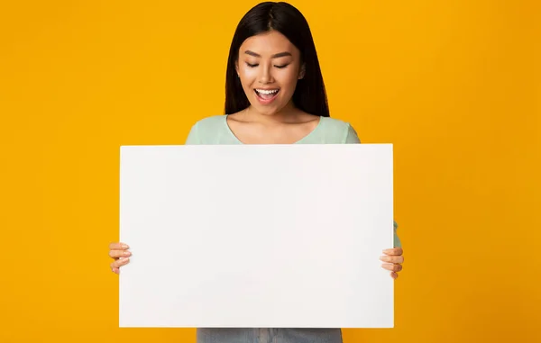 Espacio libre para la publicidad. Chica asiática sosteniendo tablero vacío — Foto de Stock