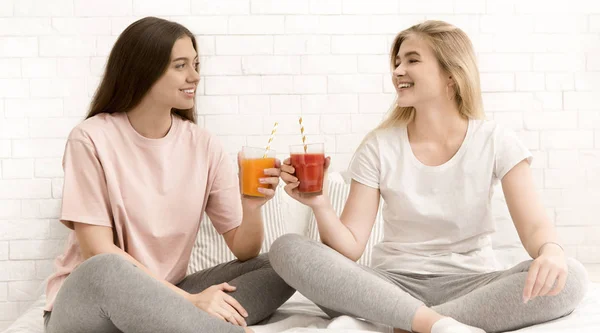 Dos novias mirándose, sonriendo y bebiendo batido fresco —  Fotos de Stock