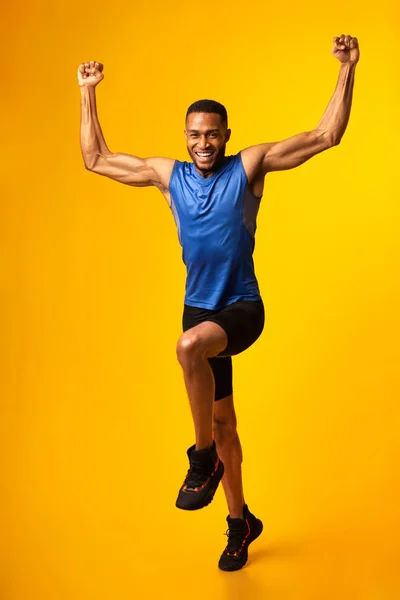 Volledige lengte afro guy vieren triomf springen in studio — Stockfoto