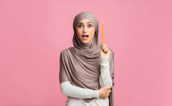 Chica musulmana inspirada teniendo idea, sosteniendo el lápiz en el brazo levantado — Foto de Stock