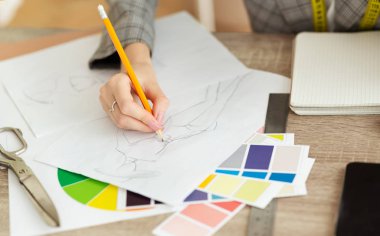Moda kariyeri. Giysiler için çizimler yapan tasarımcı
