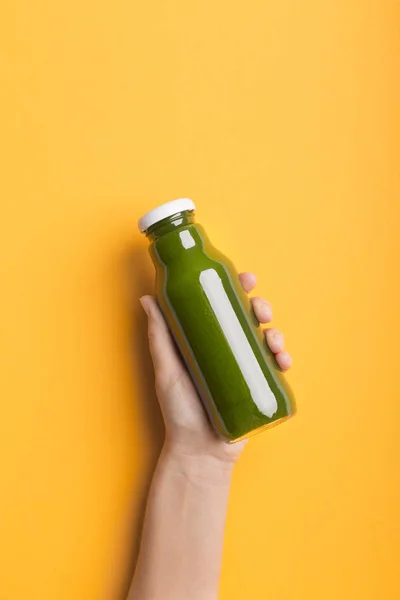 Tangan wanita memegang botol dengan detox smoothie hijau — Stok Foto