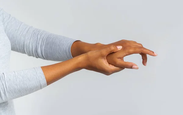 Recortado de negro chica masajeando su mano articulaciones — Foto de Stock