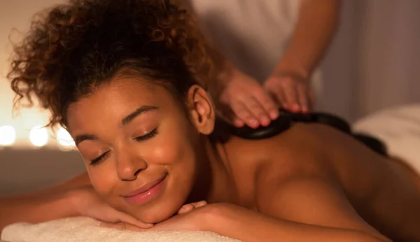 Entspannte Afro-Frau genießt Rückenstein-Massage — Stockfoto
