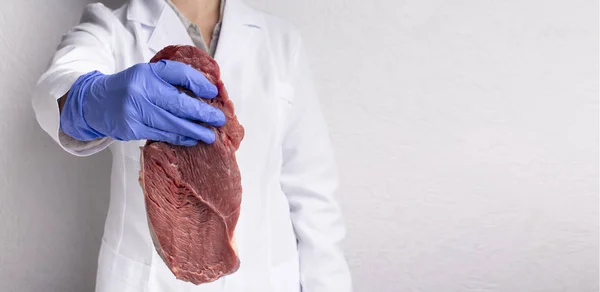 Cientista segurando carne fresca crua na mão estendida — Fotografia de Stock