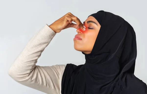 Sick black muslim woman touching red inflamed zone on nose bridge — Stock Photo, Image