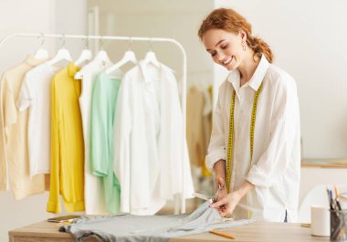 Yeni koleksiyon. Kumaşı makasla kesen terzi