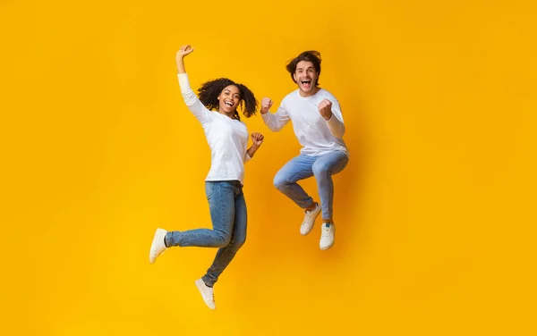 陽気な女の子とハンサムな男が空気中でジャンプ,一緒に楽しみを持っている — ストック写真