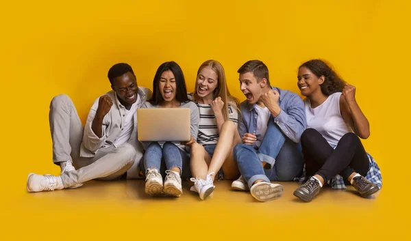 A diákok csoportja online ellenőrzi a vizsgaeredményeket sárga háttér felett — Stock Fotó