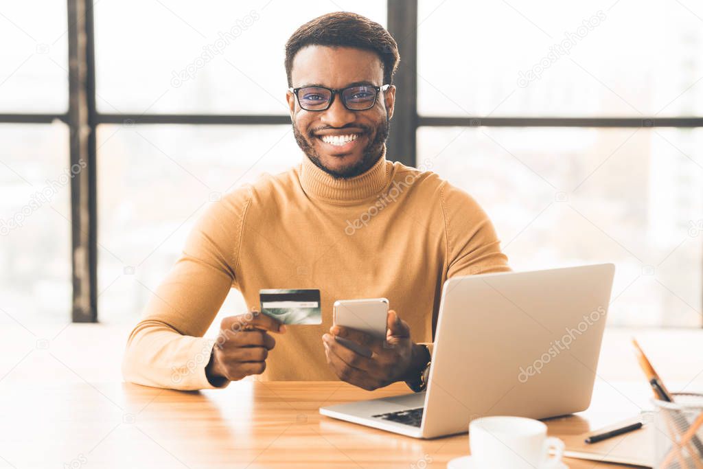 Afro manager making purchases using laptop computer