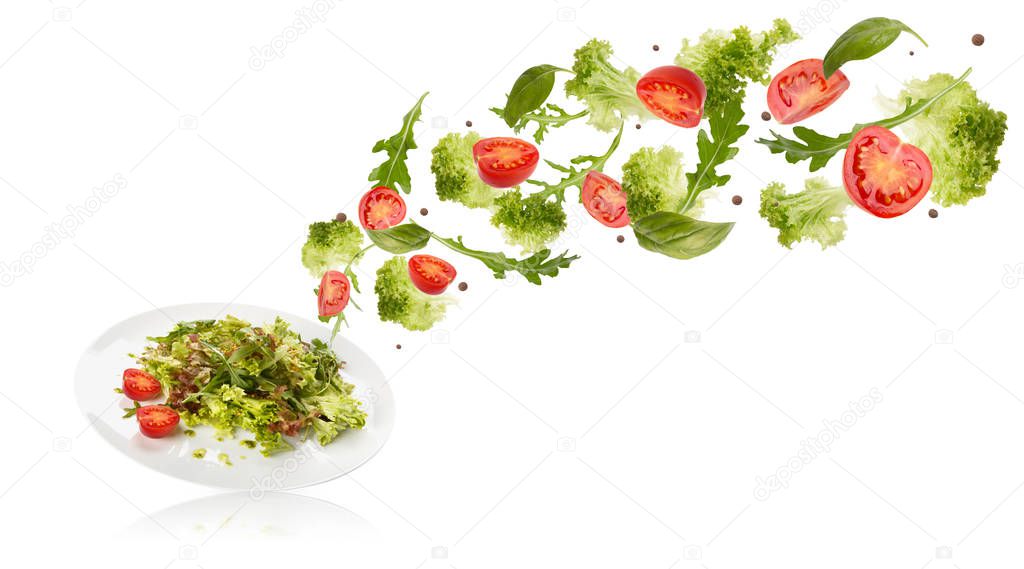 Healthy salad with flying vegetables ingredients on white