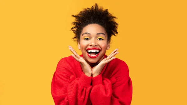 Happy afro woman screaming and touching cheeks — Stock Photo, Image