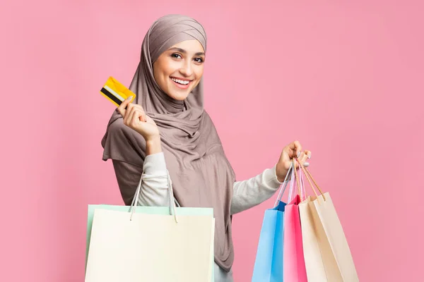 Menina árabe feliz com cartão de crédito e sacos de papel brilhante comprador — Fotografia de Stock