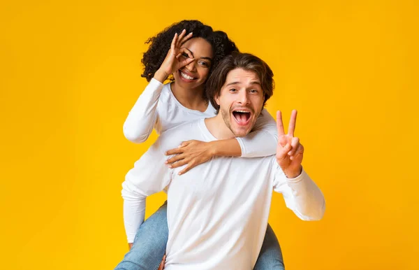 Glad interracial par lura tillsammans och visar roliga gester — Stockfoto