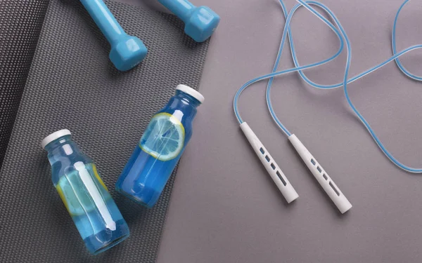 Detox isotonic water with lemon slices and gym accessories — 스톡 사진
