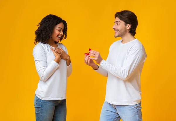 Tipo romántico proponiendo a su novia sorprendida, dando anillo — Foto de Stock