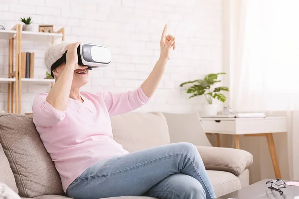 Mujer mayor disfrutando de gafas VR en casa — Foto de Stock