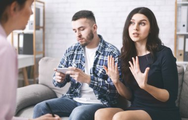 Kızgın kadın çift terapisinde psikiyatrist ile konuşuyor.