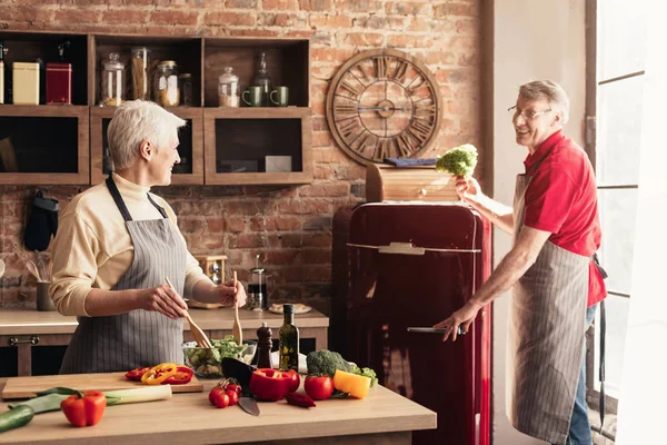 Senior hilft seiner Frau beim Kochen in der Küche — Stockfoto