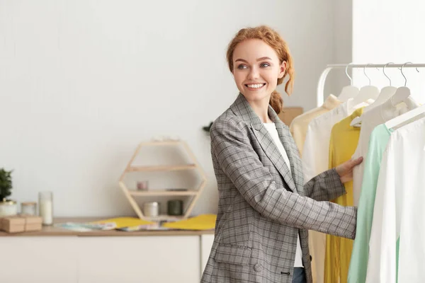 Gelukkig vrouw koopt nieuwe kleren in showroom — Stockfoto