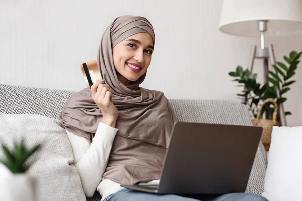 Happy muslim wanita dalam jilbab dengan laptop dan kartu kredit — Stok Foto