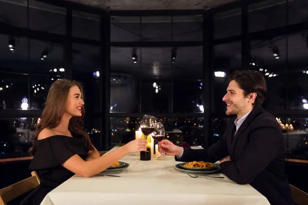 Мужчина и женщина в любви звонят бокалы вина в ресторане — стоковое фото