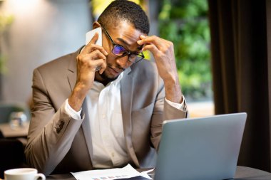 Odaklanmış afro iş adamının telefon görüşmesi yaptığı portre.
