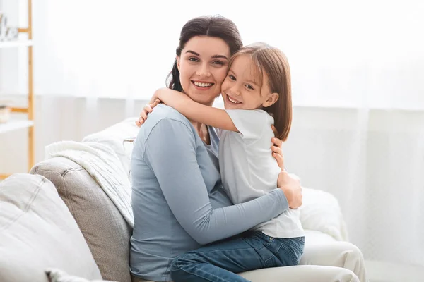 Liefdevolle kleine dochter knuffelen haar verwachten moeder — Stockfoto