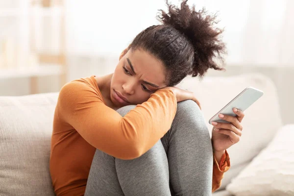 Sad Woman Holding Cellphone Sitting On Couch At Home — Stock Photo, Image