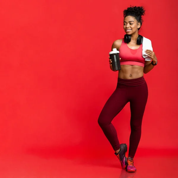 Healthy sporty girl holding shaker with protein