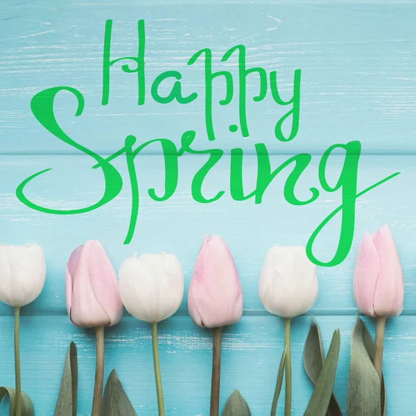 Feliz texto de primavera con flores en madera blanqueada — Foto de Stock