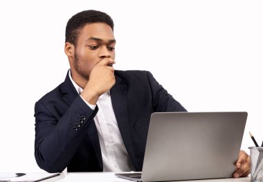 Ofiste laptopuyla çalışan siyahi bir adam.
