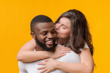 Sevgi dolu bir kadın, arka taraftaki afro sevgilisini öpüyor ve sarılıyor.