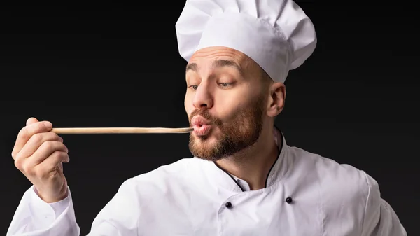 Chef Man Holding Spoon degustacja żywności na czarnym tle, Panorama — Zdjęcie stockowe