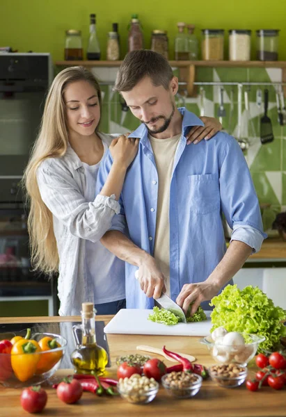 Leende vegetariskt ungt par som lagar hälsosam mat — Stockfoto