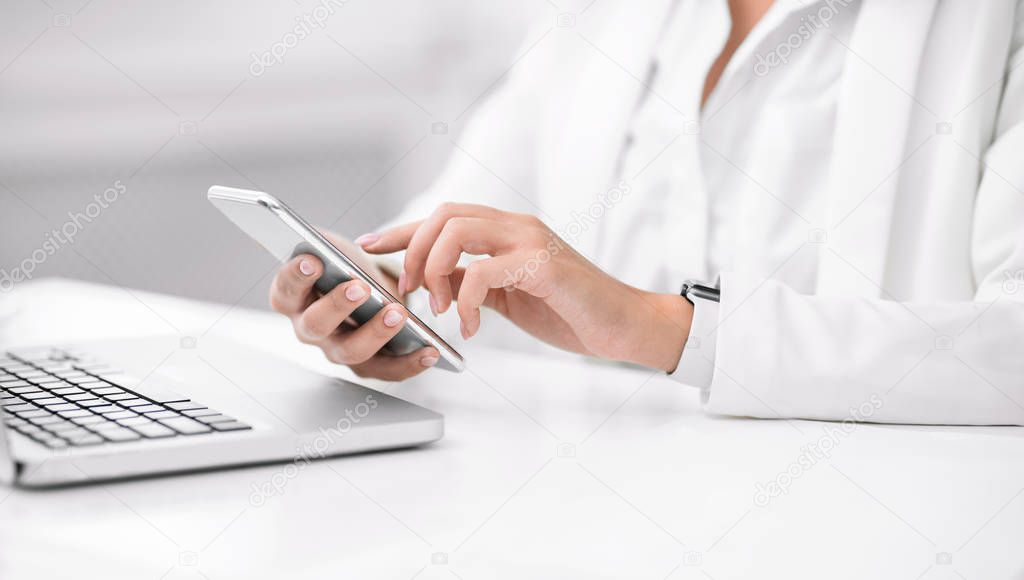 Mexican businesswoman using laptop and cell phone