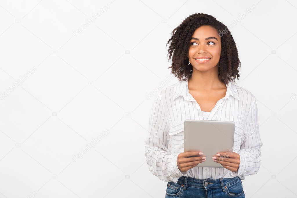Afro woman with tablet looking at empty space