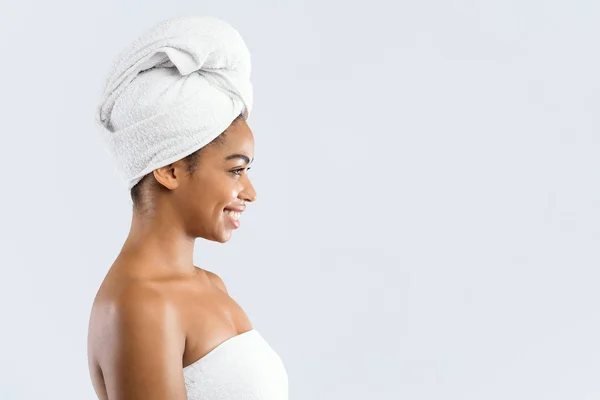 Uśmiechnięta kobieta owinięta w ręczniki patrząc na przestrzeń do kopiowania — Zdjęcie stockowe