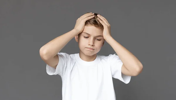 Upset teen boy holding head in despair — Stock Photo, Image