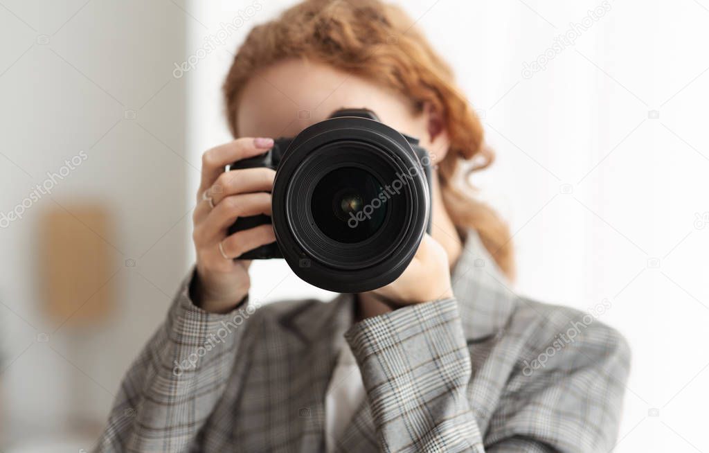 Woman photographer taking photographs on dslr camera