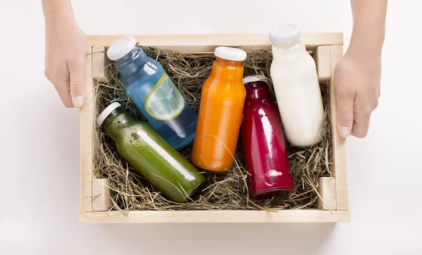 Female holding wooden box with Different flavoured detox drinks — 스톡 사진