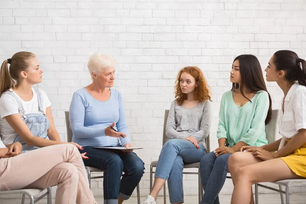 Psicólogo conversando com as mulheres durante a reunião do grupo de apoio sentado dentro de casa — Fotografia de Stock