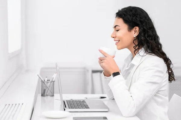 Mexicaans meisje drinken van thee en met behulp van personal computer — Stockfoto