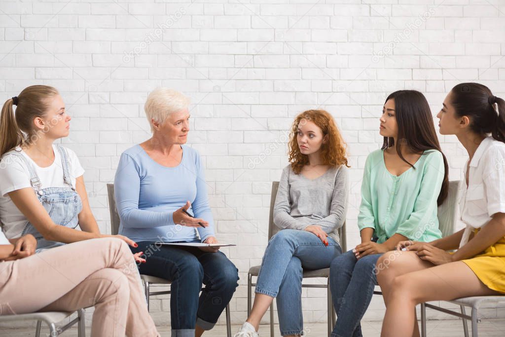 Psychologist Talking With Women During Support Group Meeting Sitting Indoor