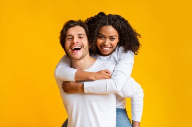 Sırtına al. Afro kız arkadaşını sırtında taşıyan şefkatli bir adam..